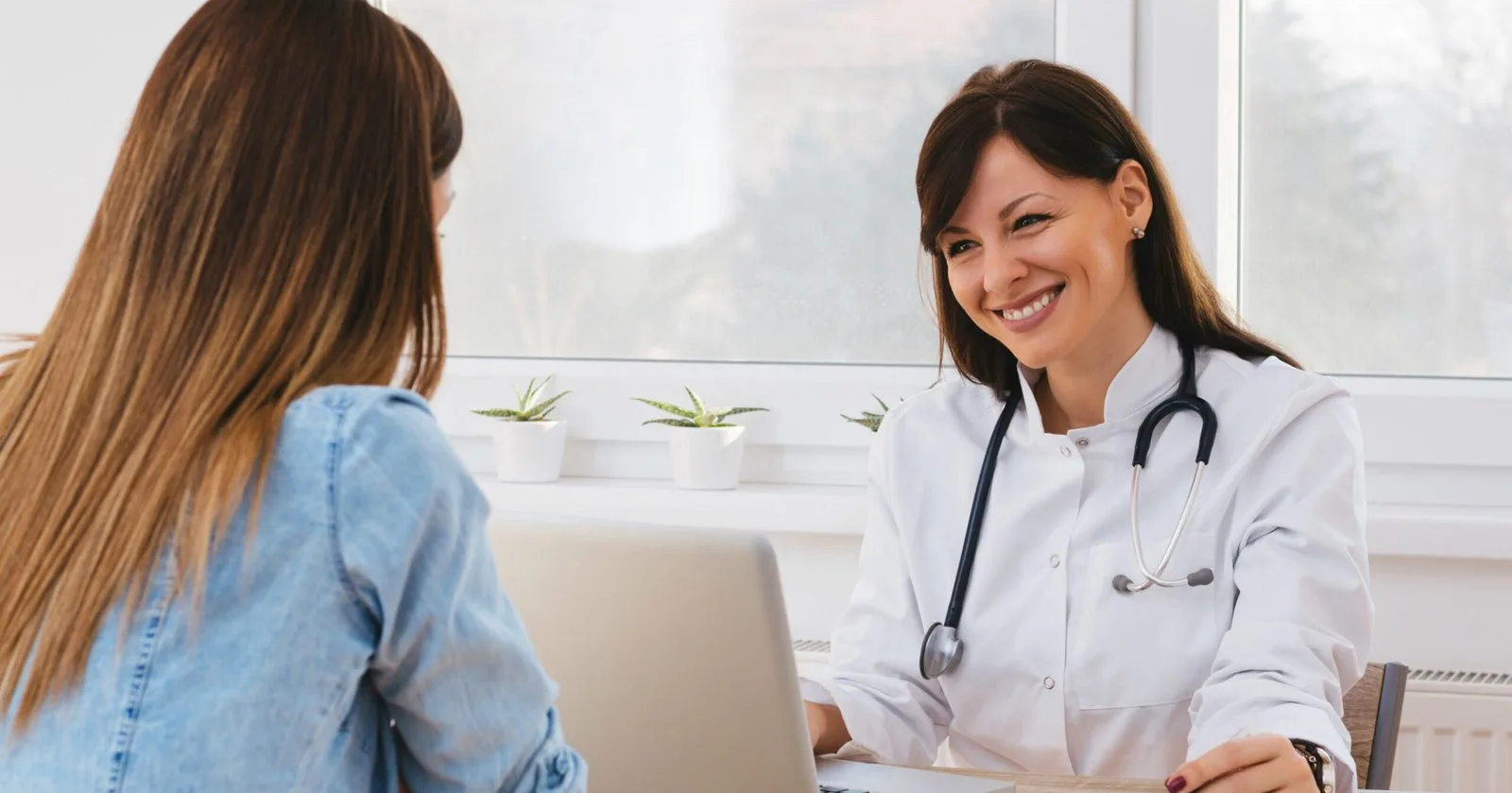 Médica sorrindo durante consulta com uma paciente