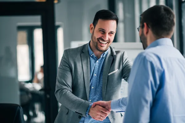 Dois homens apertando as mãos após fechar contrato