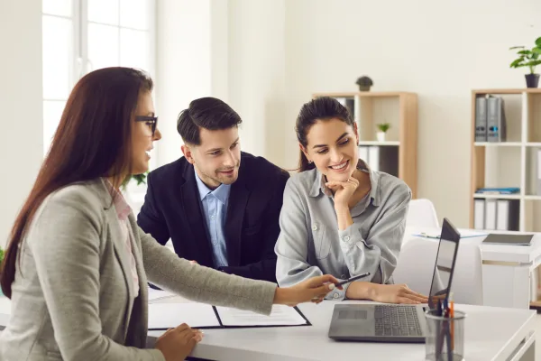 Casal em reunião com consultora analisando propostas