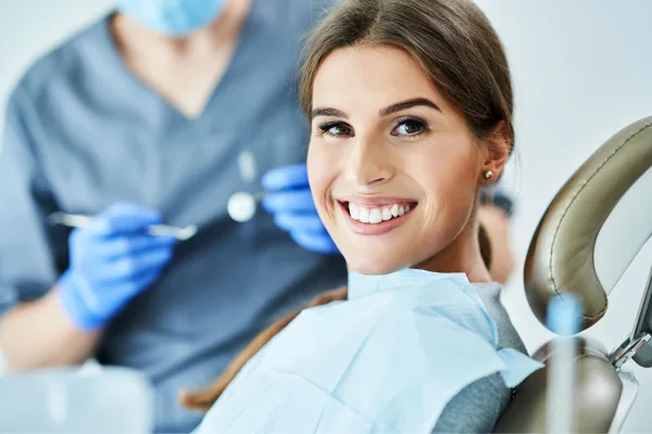 Paciente sorrindo em atendimento odontológico